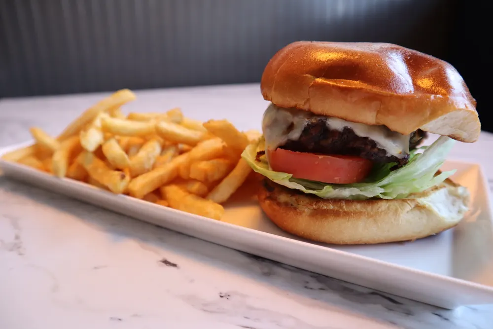 A cheeseburger served with French fries