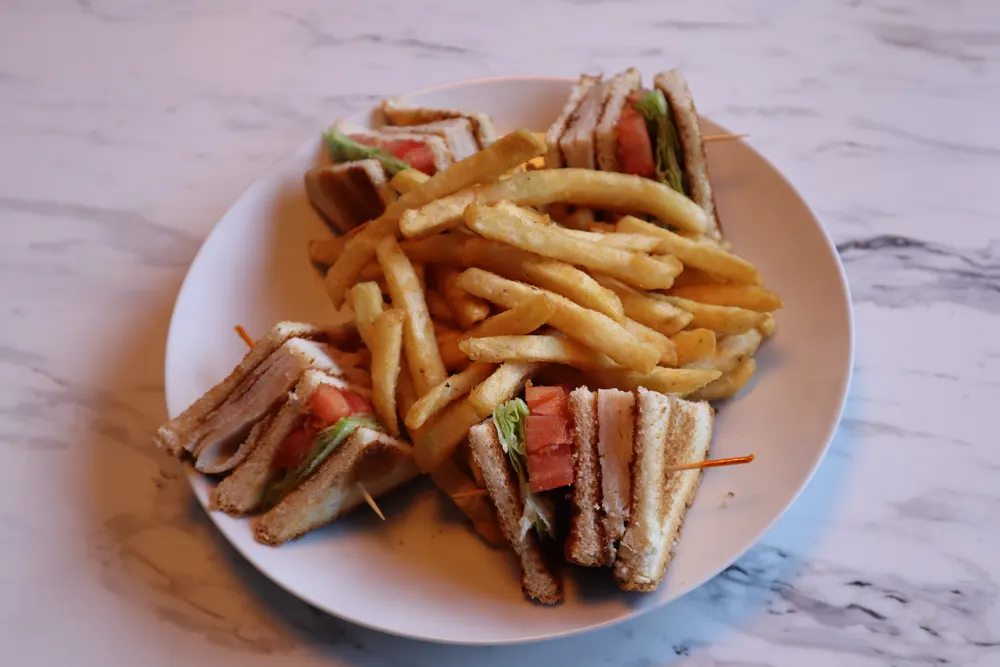 A triple-decker club sandwich with French fries
