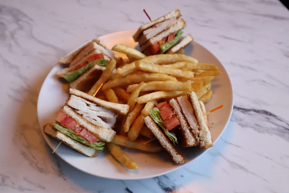A triple-decker club sandwich with fries