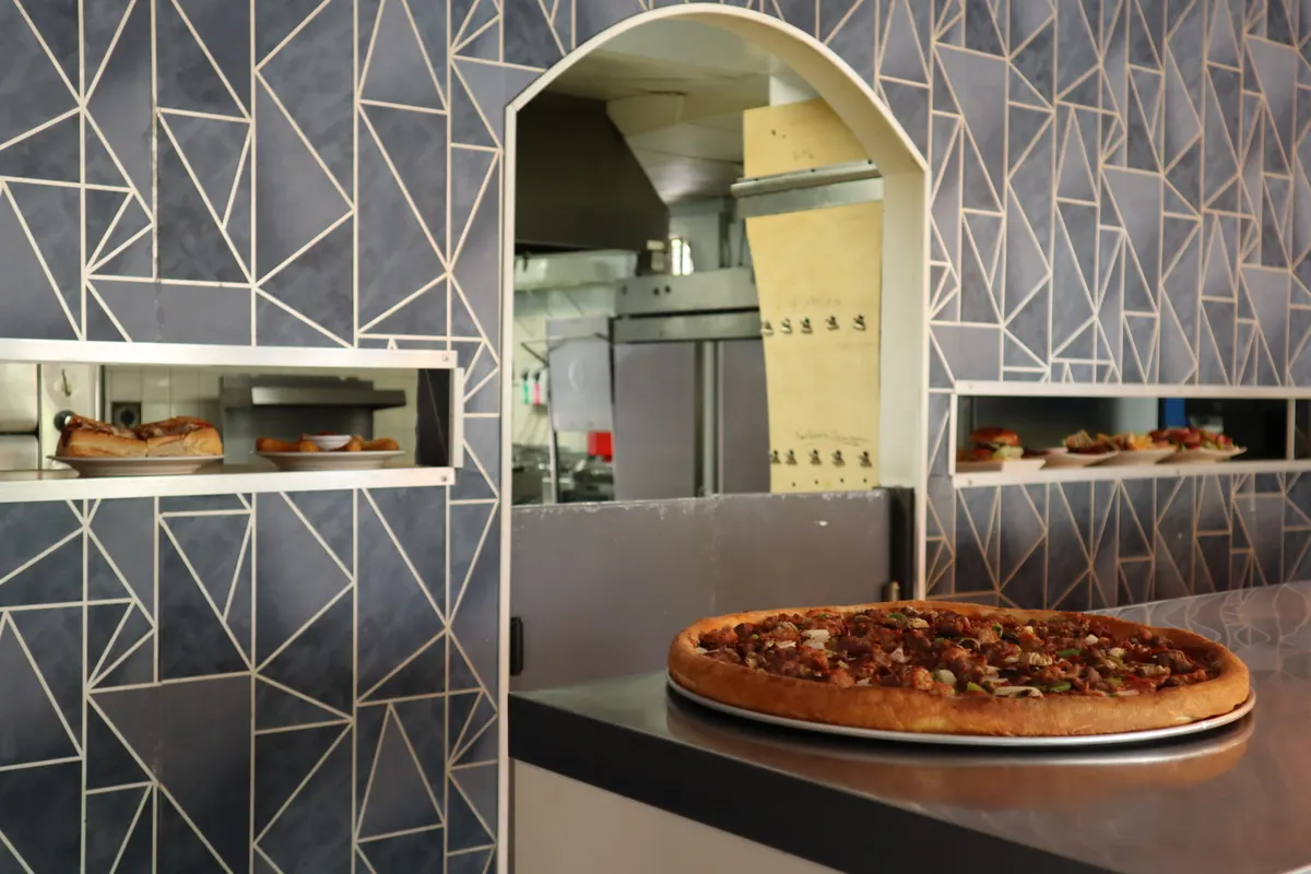 A loaded specialty pizza on the counter