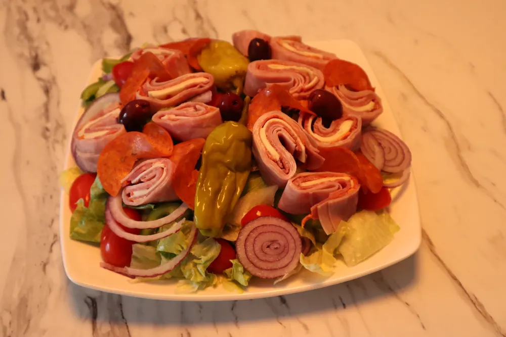 An antipasto salad with cured meats, olives and peppers