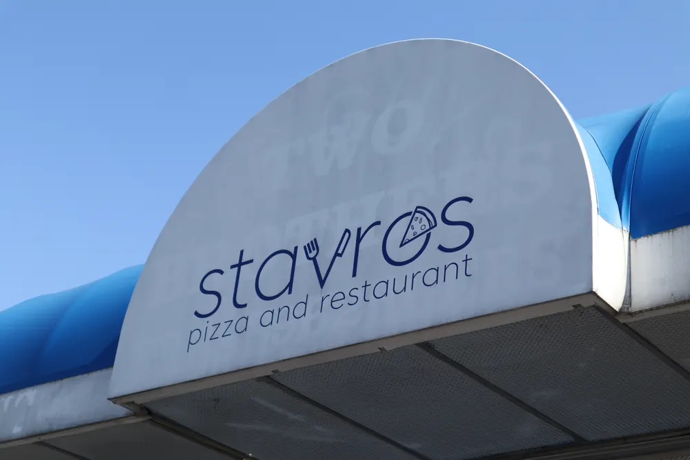 The blue Stavros Pizza and Restaurant sign